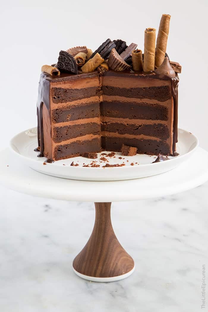 interior cut of layered chocolate cake on white cake stand. 