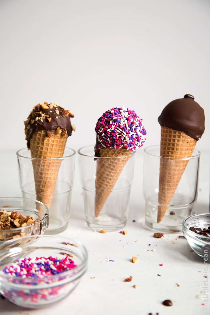 Sugar cones filled with coconut ice cream dipped in chocolate and topped with a variety of sprinkles.