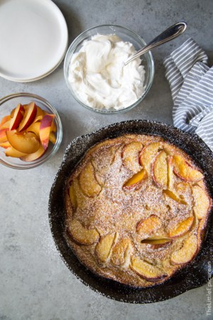 Whiskey Peach Clafoutis baked in cast iron skillet.