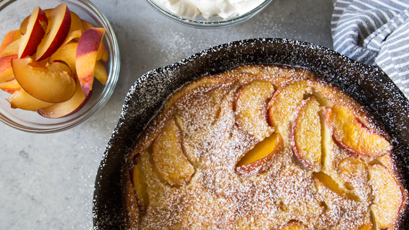 Whiskey Peach Clafoutis baked in cast iron skillet.