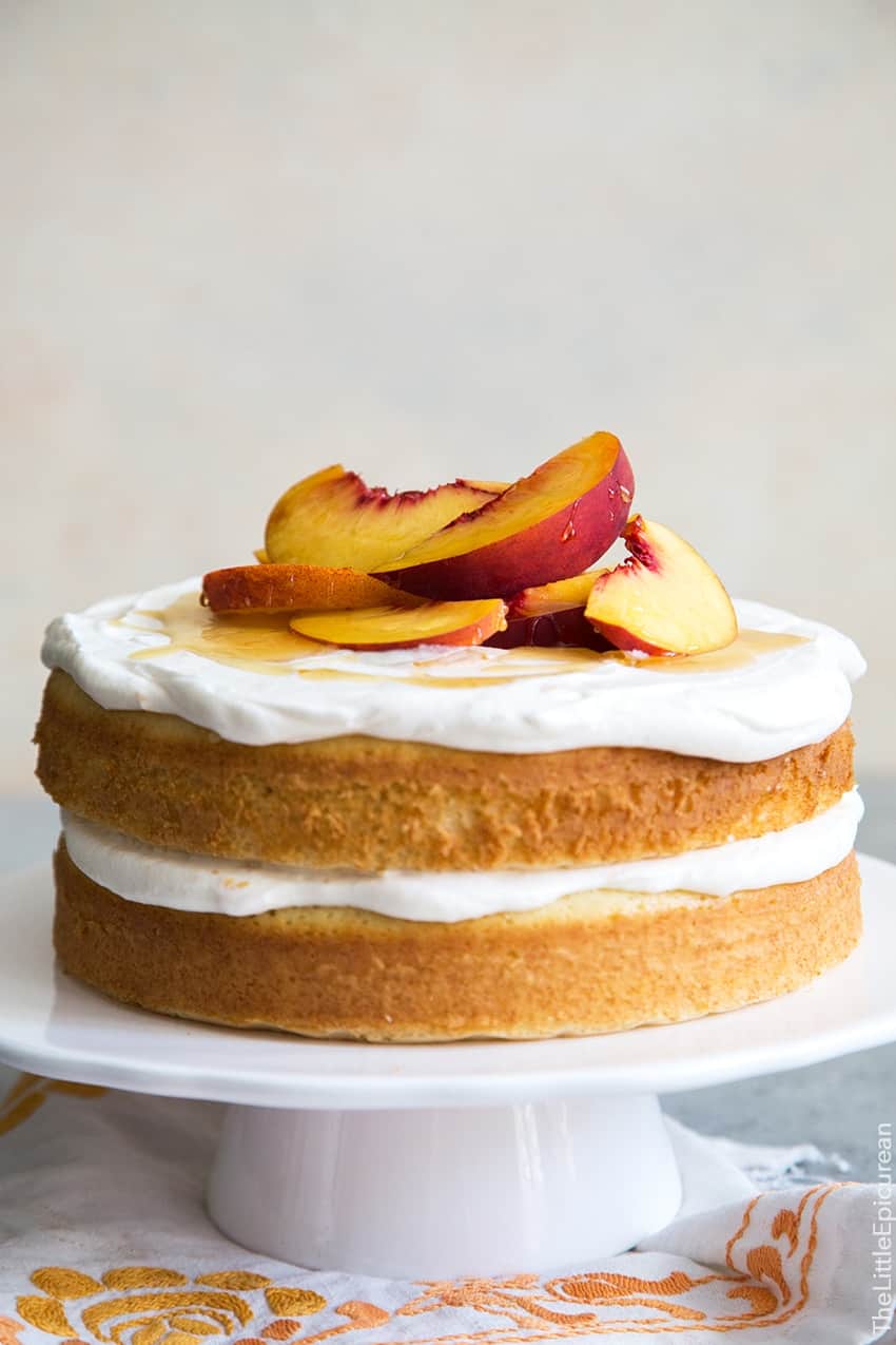 Peach Bellini Cake on white cake stand. 