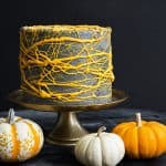Black Sesame Cake with Marshmallow Webs surrounded by mini pumpkins.