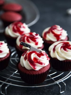 Bloody Red Velvet Cupcakes with raspberry sauce and mini sugar cleaver knife.