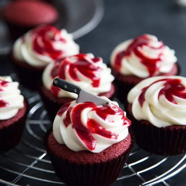Bloody Red Velvet Cupcakes with raspberry sauce and mini sugar cleaver knife.