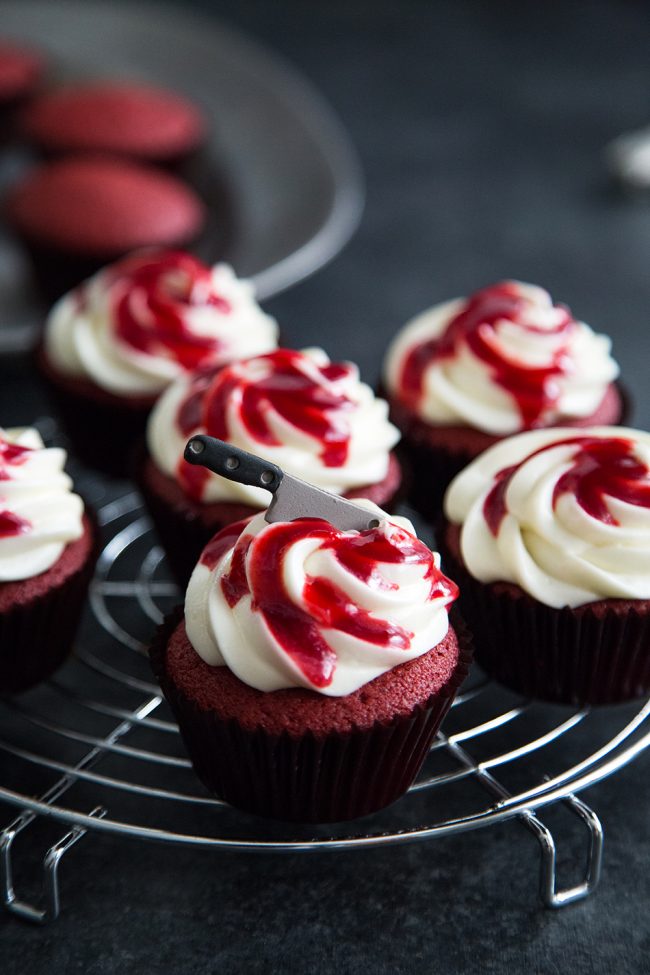 Bloody Red Velvet Cupcakes with raspberry sauce and mini sugar cleaver knife.