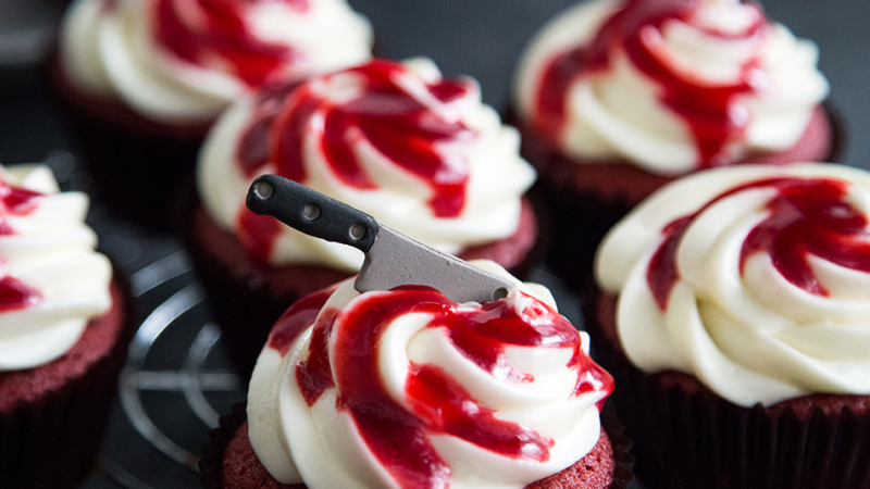 Bloody Red Velvet Cupcakes with raspberry sauce and mini sugar cleaver knife.