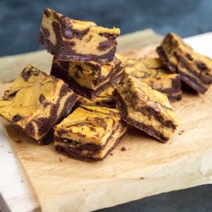 Pumpkin Cheesecake Swirl Brownies on wood cutting board.
