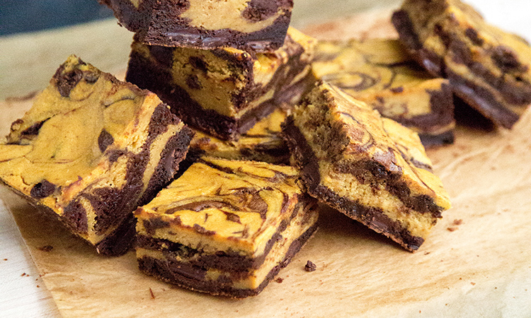 Pumpkin Cheesecake Swirl Brownies on wood cutting board.