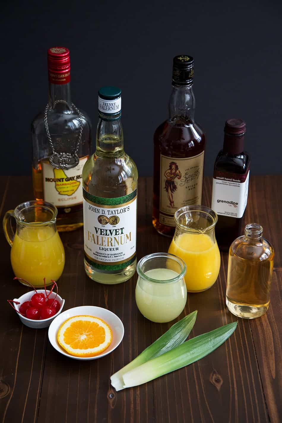 ingredients to make zombie cocktail ingredient falernum, rum, orange juice, and pineapple juice.