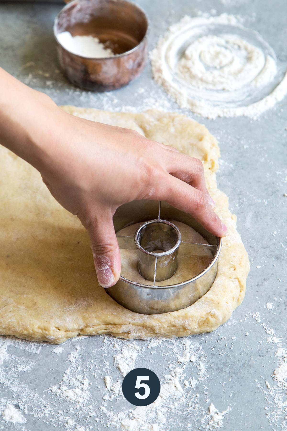pat chilled dough to even layer and stamp out donut rounds.