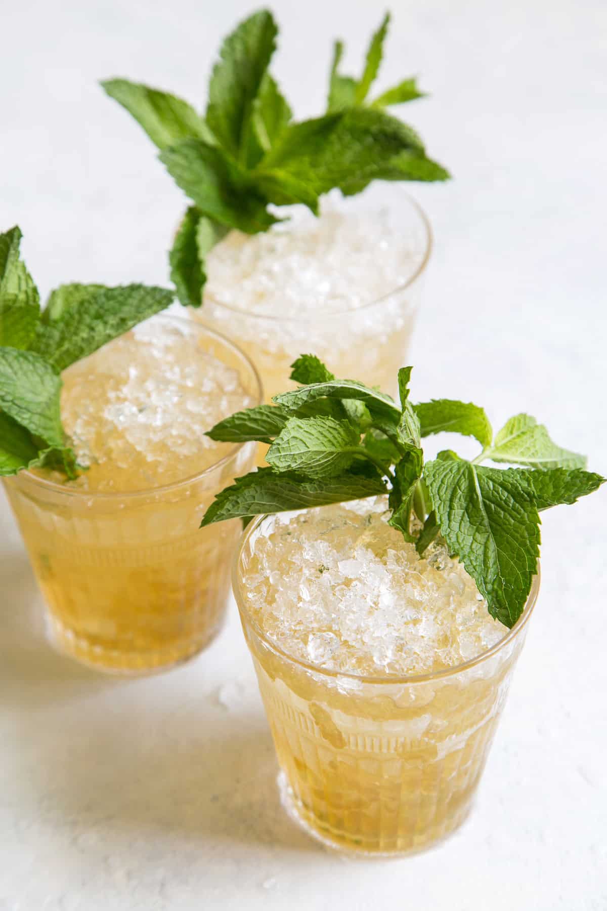 close up of three mint julep cocktails garnished with fresh mint