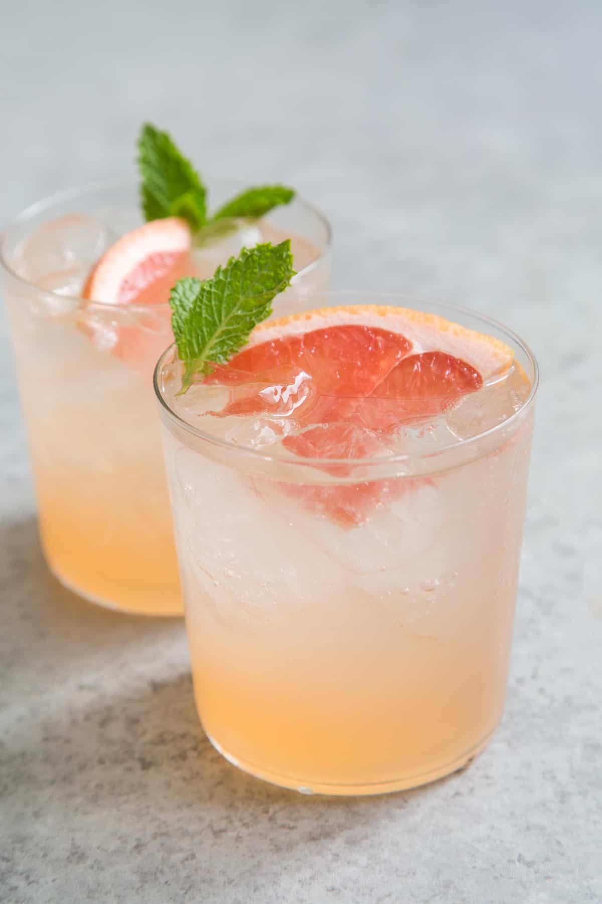 Grapefruit Cinzano cocktail garnished with grapefruit wedge and fresh mint.