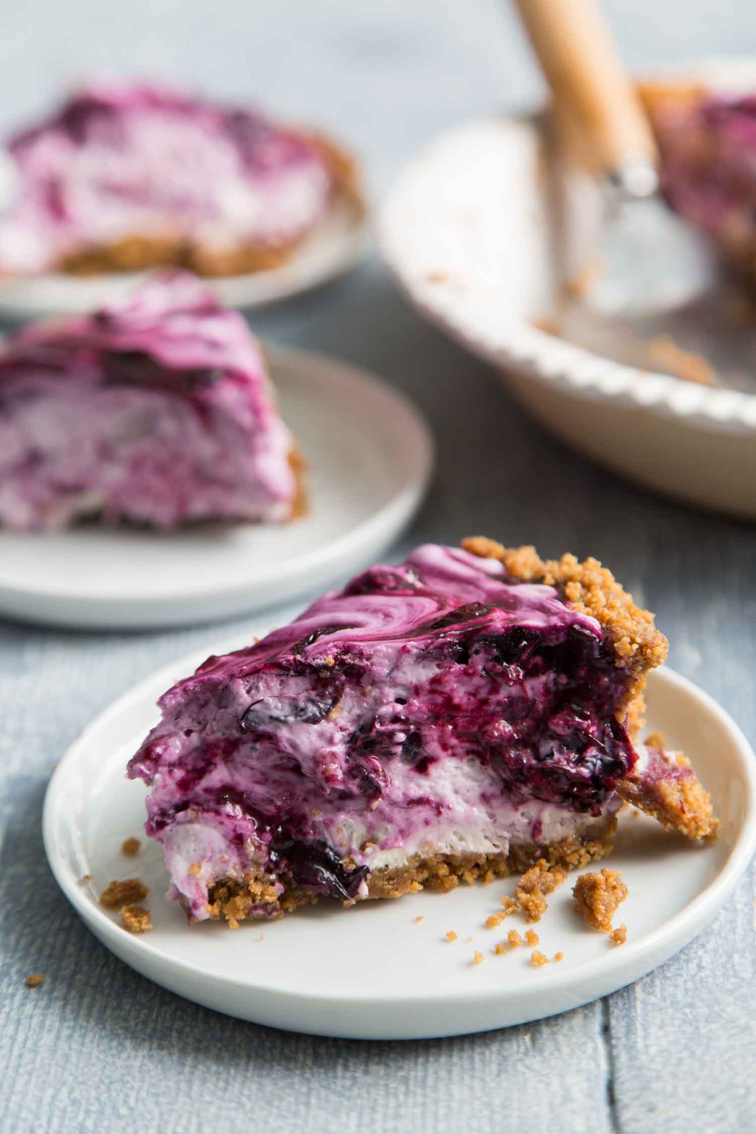 slice of blueberry icebox pie with cookie crust on white dessert plate. 