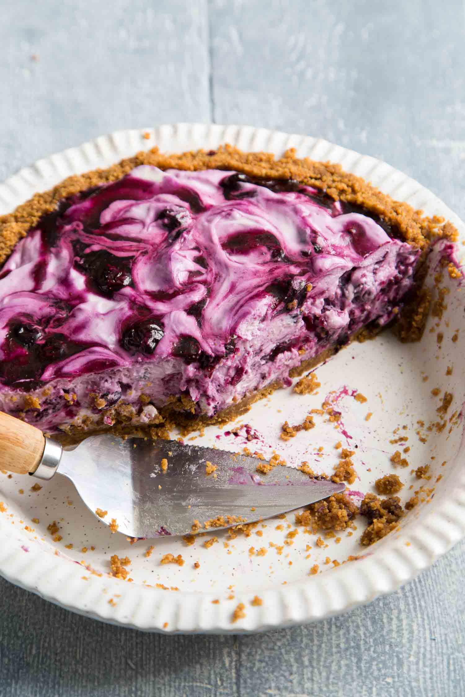 sliced up blueberry icebox pie in white pie plate. 