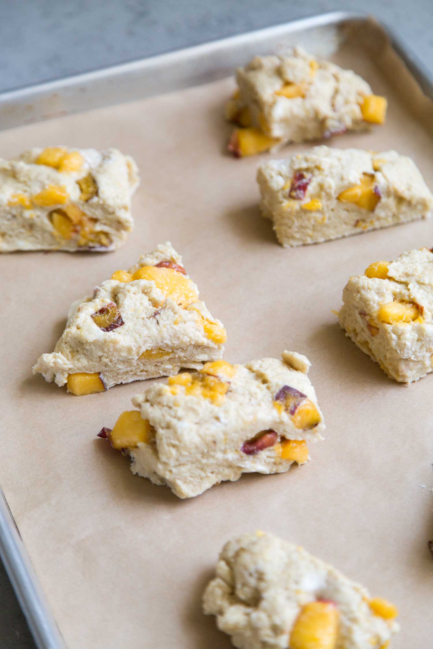 unbaked nectarine scones placed on parchment lined baking sheet. 