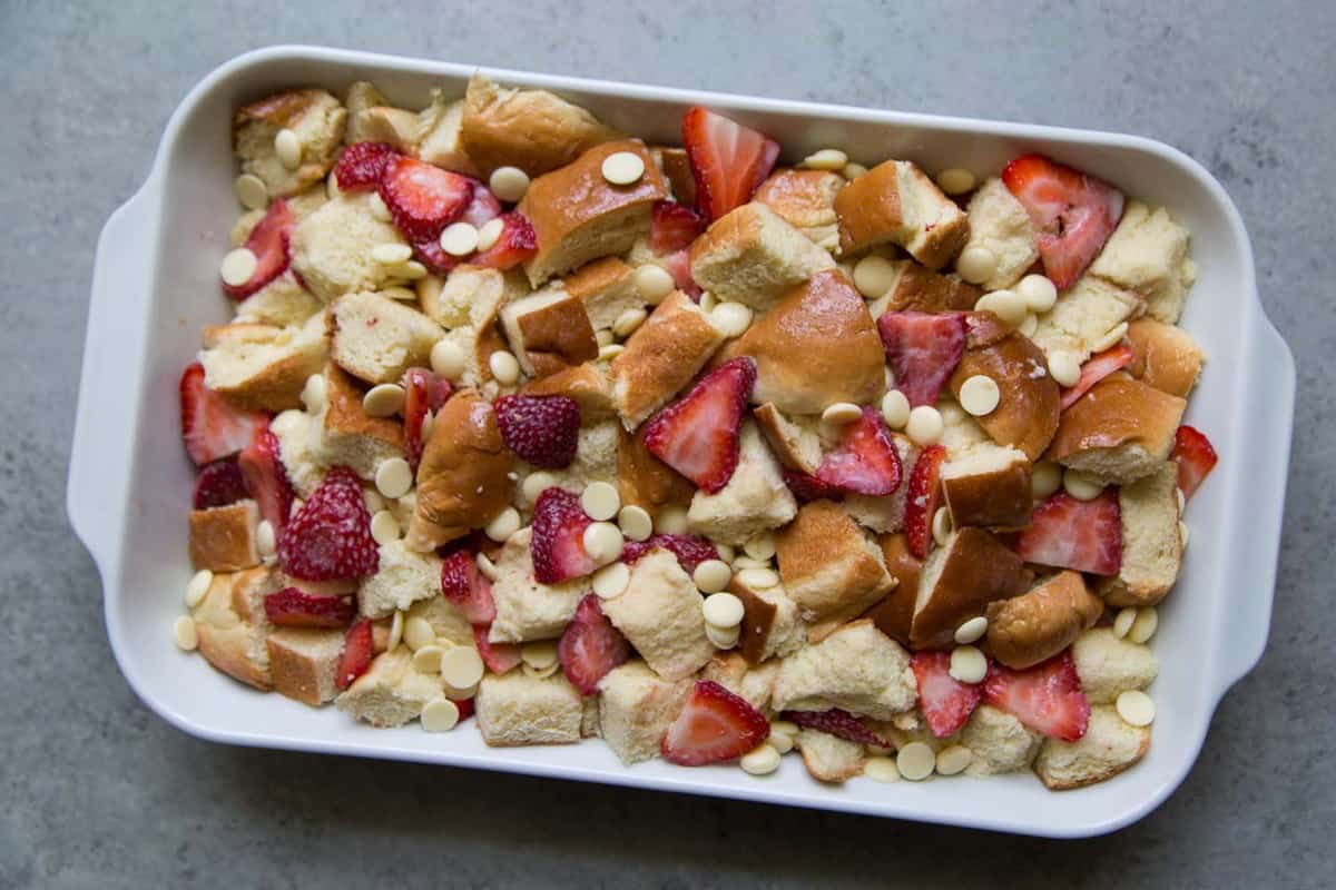 White Chocolate Strawberry Bread Pudding in white casserole dish before baking. 