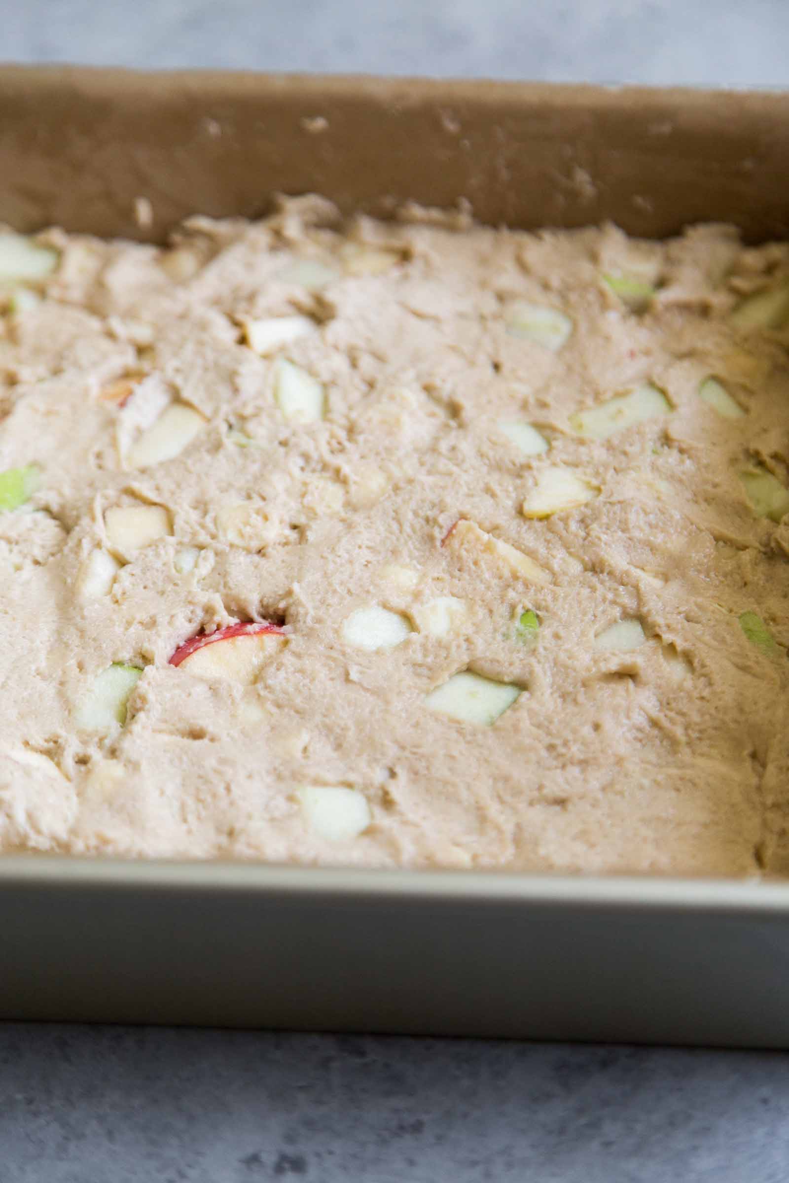 apple blondie batter pressed into an even layer in 8-inch square pan.