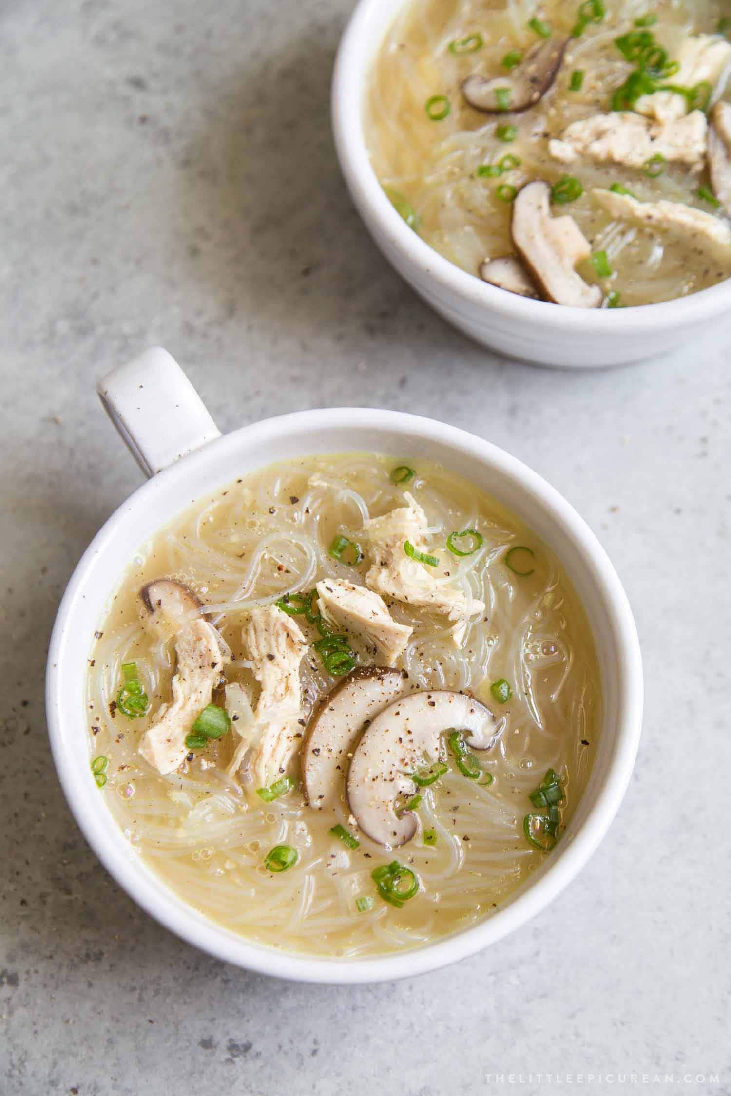 Chicken Sotanghon Soup in a bowl garnished with black pepper and green onions. 