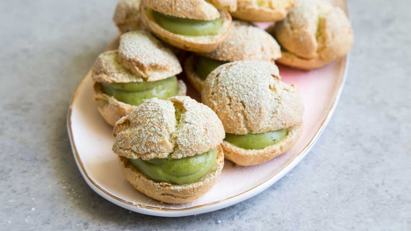 Matcha Cream Puffs arranged on pink serving plate.