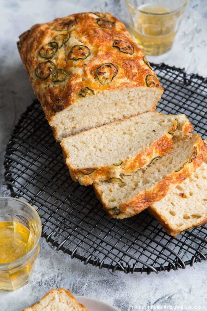 spicy cheese beer bread slices on black wire rack.