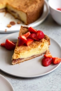 Basque Cake served with fresh strawberries. Basque cake is a buttery cake with a pastry cream filling.