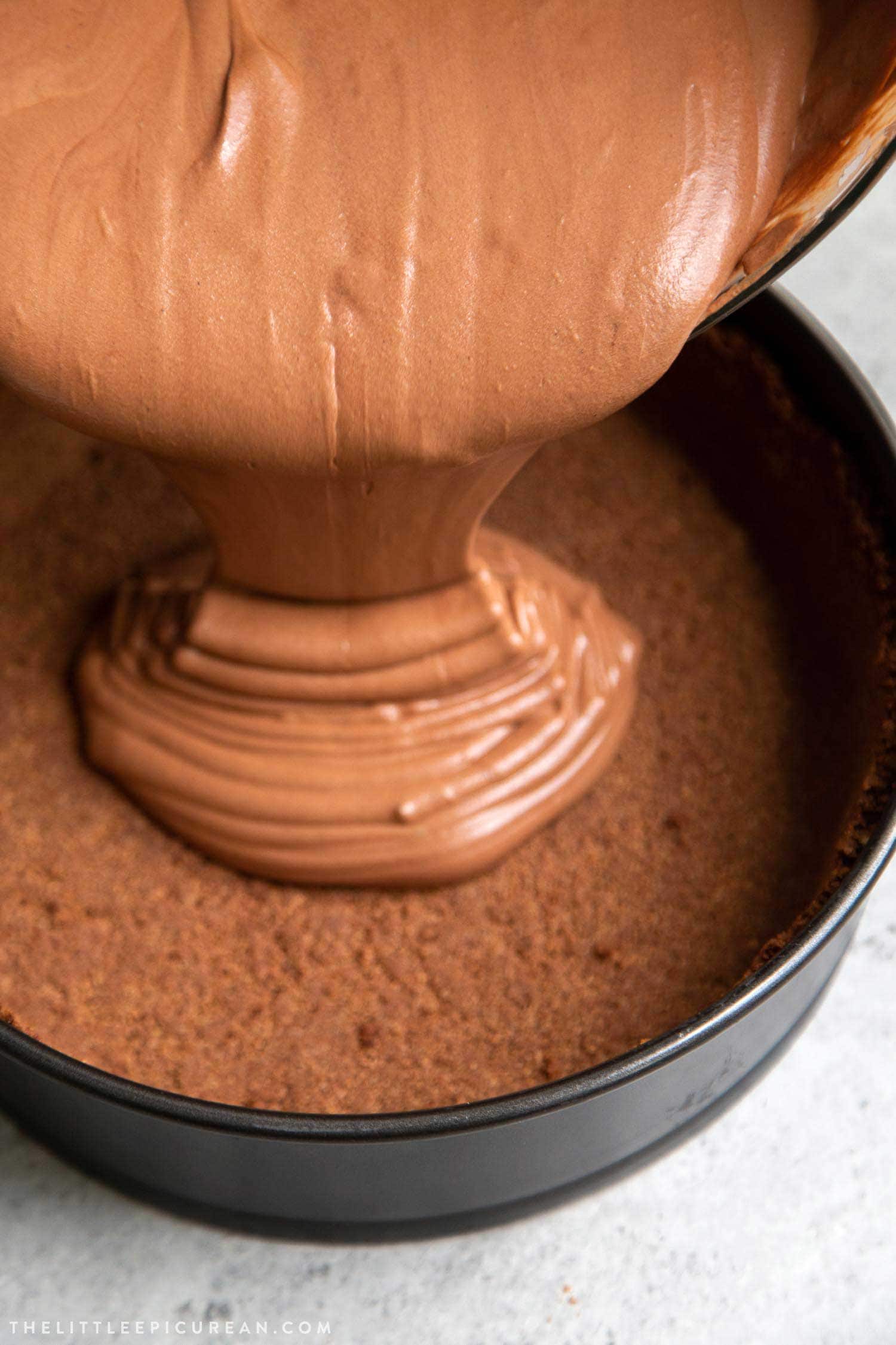 Pouring chocolate mousse into chocolate graham cracker pie shell