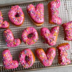 Letter Donuts with pink glaze and rainbow sprinkles. Send your loved ones using donuts!