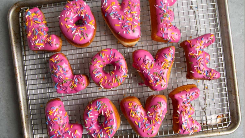 Letter Donuts with pink glaze and rainbow sprinkles. Send your loved ones using donuts!