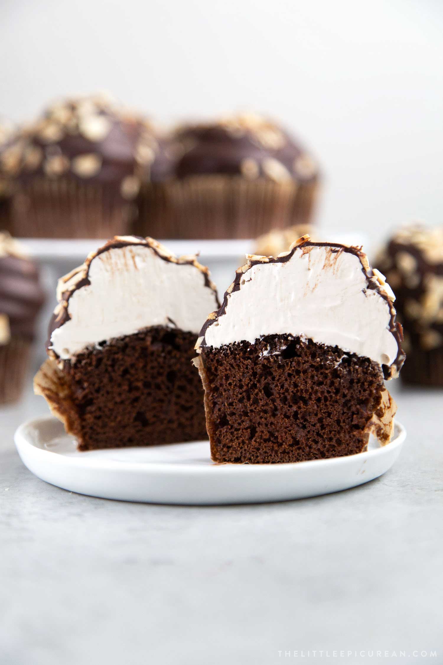 Almond Mocha Hi-Hat Cupcakes. Cross section of chocolate cupcakes topped with espresso meringue dipped in chocolate and topped with toasted almonds.