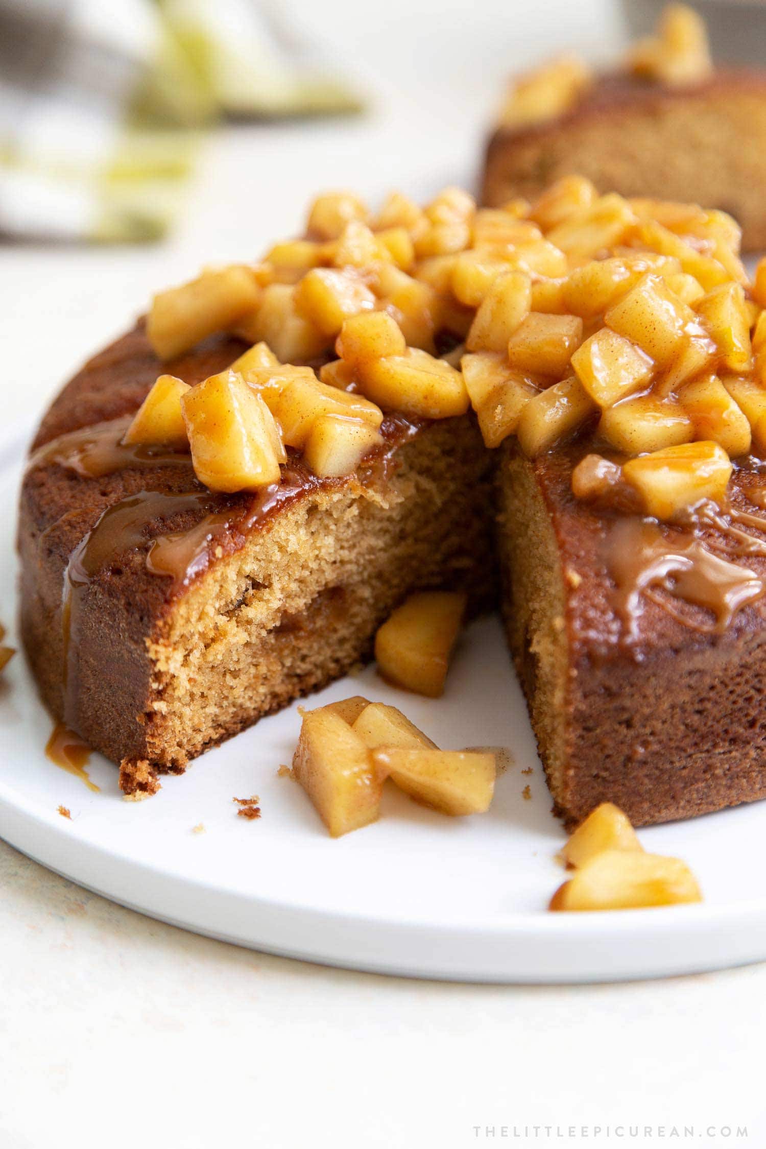 Apple Ginger Cake. Moist ginger cake is flavored with fresh grated ginger and candied ginger pieces. The baked cake is topped with ginger spiced apples and a drizzle of caramel.