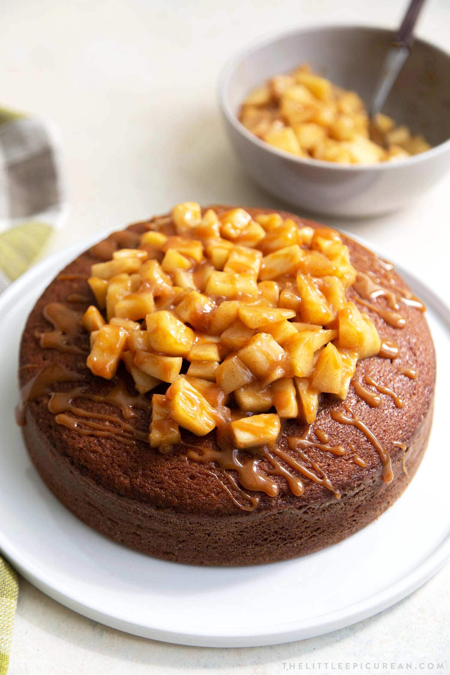 Apple Ginger Cake. Moist ginger cake is flavored with fresh grated ginger and candied ginger pieces. The baked cake is topped with ginger spiced apples and a drizzle of caramel.