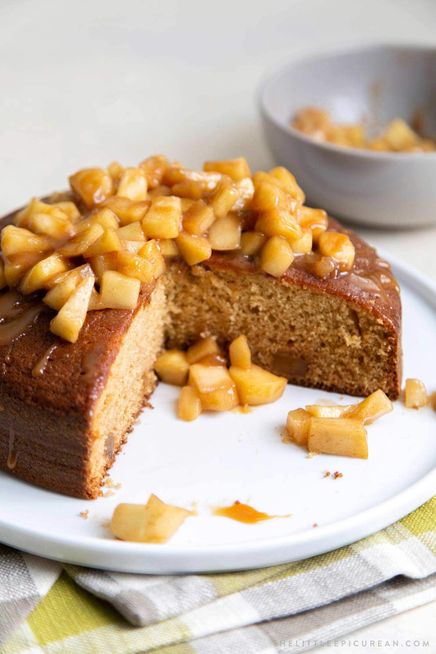 Apple Ginger Cake. Moist ginger cake is flavored with fresh grated ginger and candied ginger pieces. The baked cake is topped with ginger spiced apples and a drizzle of caramel.