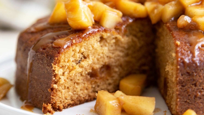 Apple Ginger Cake. Moist ginger cake is flavored with fresh grated ginger and candied ginger pieces. The baked cake is topped with ginger spiced apples and a drizzle of caramel.