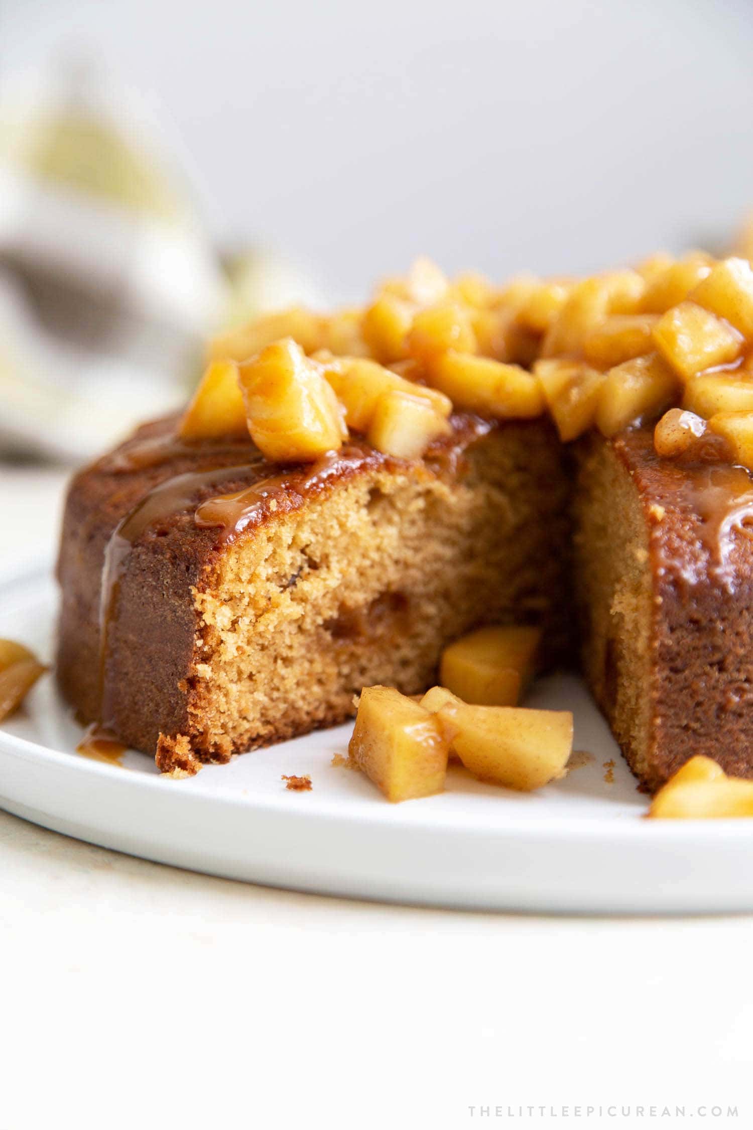 Apple Ginger Cake. Moist ginger cake is flavored with fresh grated ginger and candied ginger pieces. The baked cake is topped with ginger spiced apples and a drizzle of caramel.