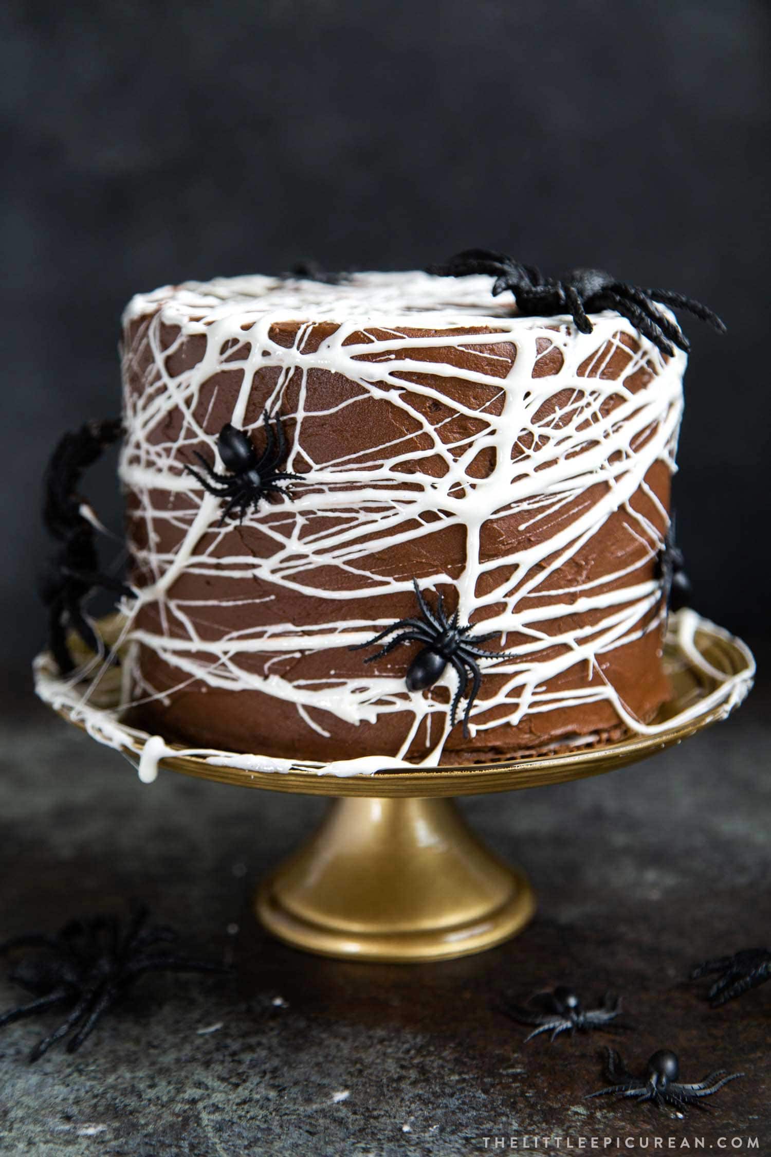 Chocolate Spider Web Cake. Three layer chocolate cake frosted with simple chocolate buttercream and decorated with marshmallow spider webs. It's the perfect Halloween treat!