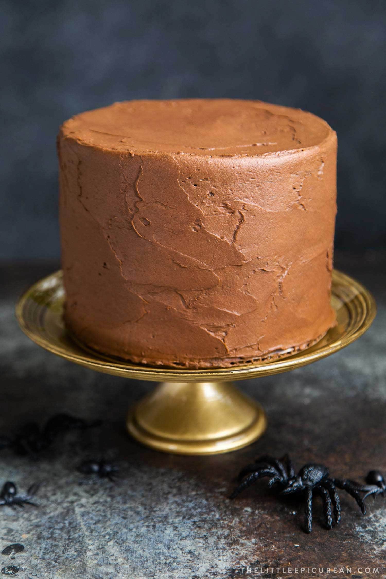 Chocolate Spider Web Cake. Three layer chocolate cake frosted with simple chocolate buttercream and decorated with marshmallow spider webs. It's the perfect Halloween treat!