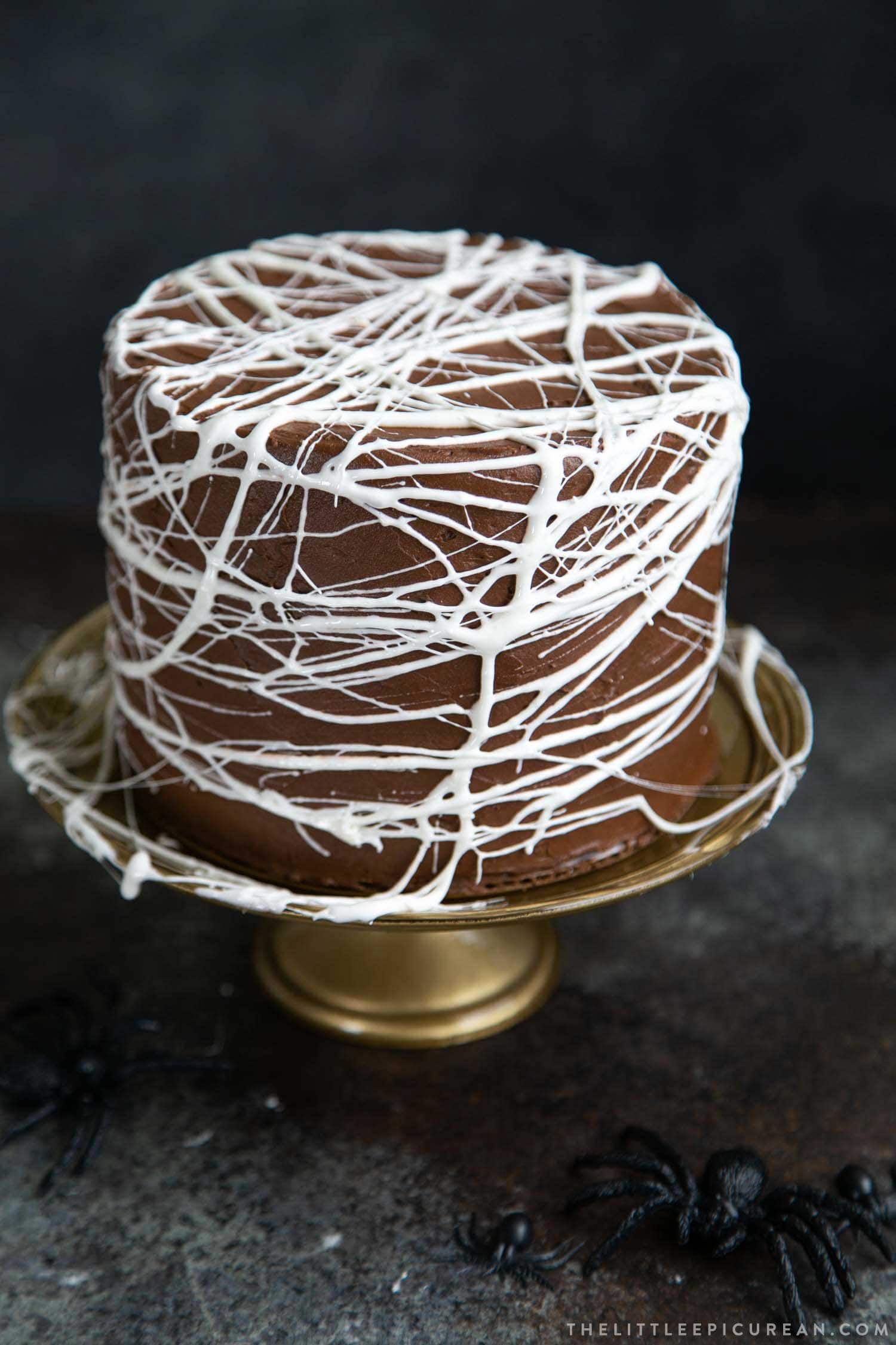 Chocolate Spider Web Cake. Three layer chocolate cake frosted with simple chocolate buttercream and decorated with marshmallow spider webs. It's the perfect Halloween treat!