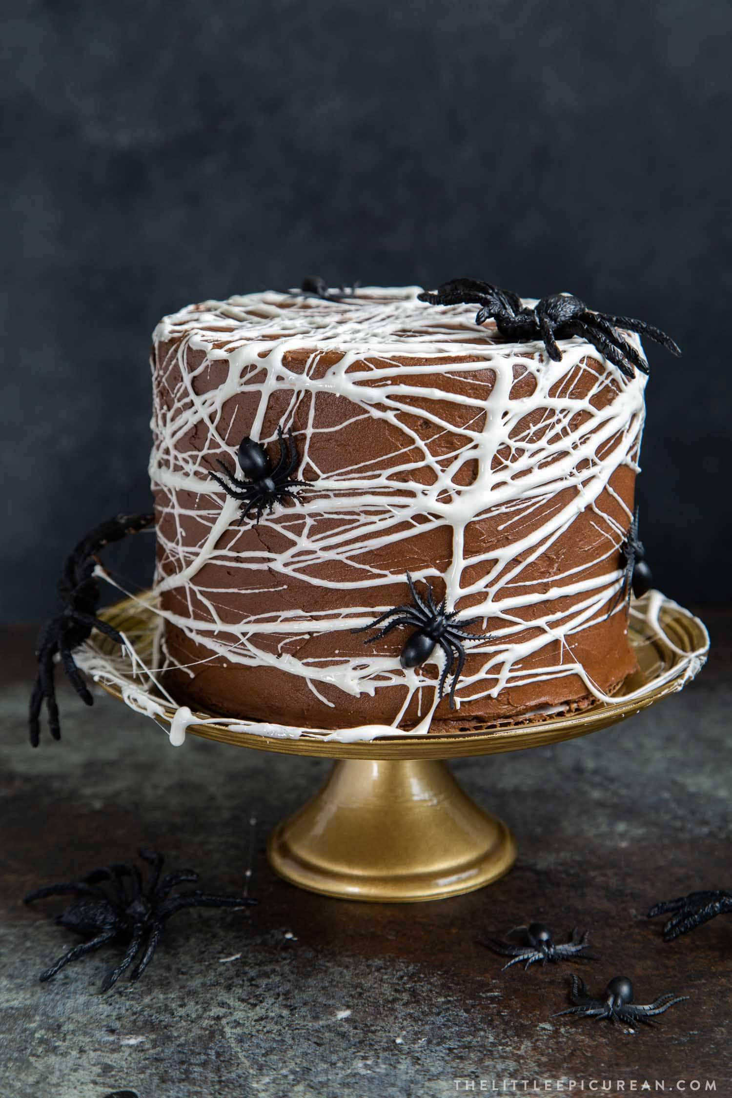 Chocolate Spider Web Cake. Three layer chocolate cake frosted with simple chocolate buttercream and decorated with marshmallow spider webs. It's the perfect Halloween treat!