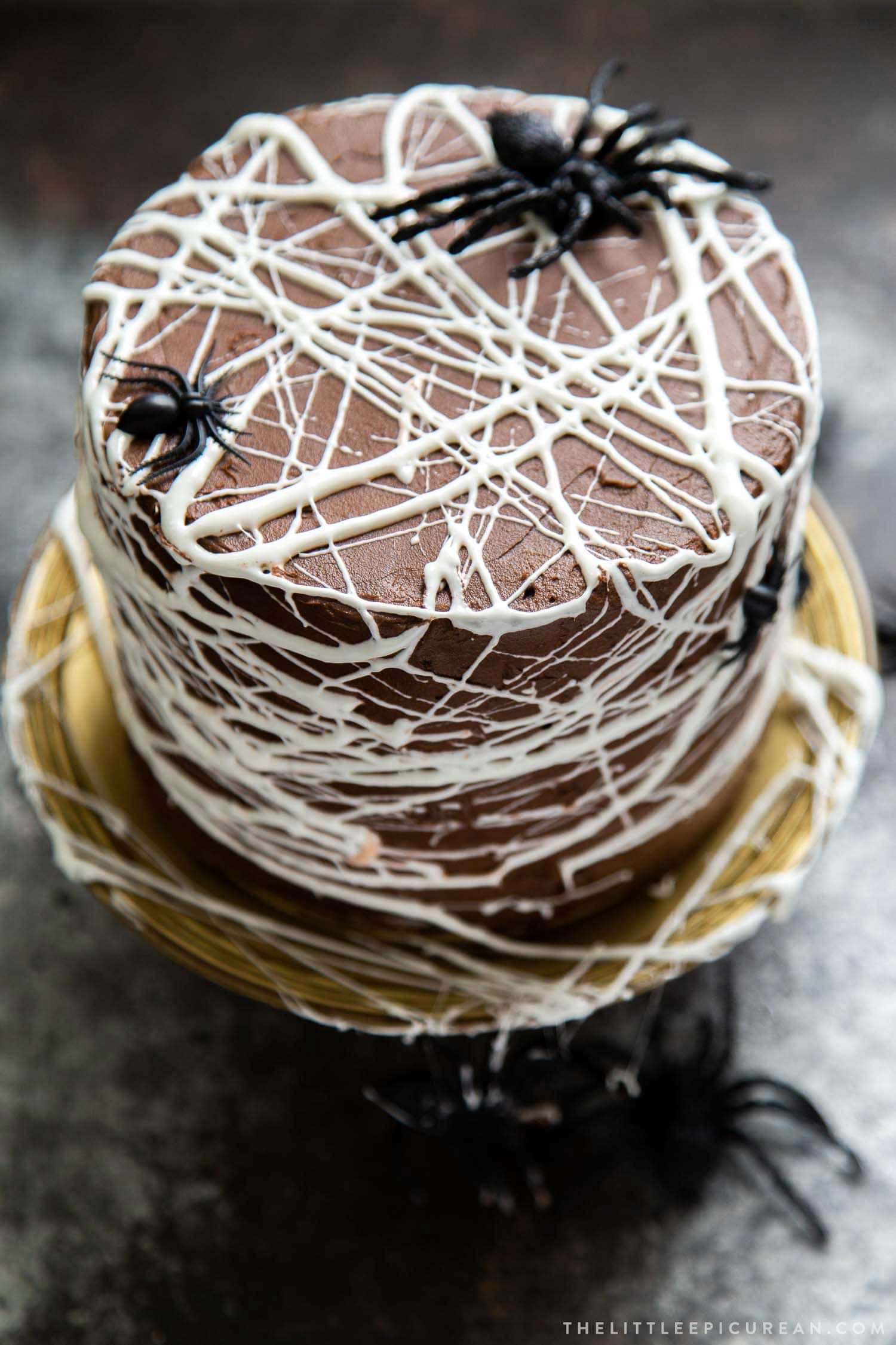 Chocolate Spider Web Cake. Three layer chocolate cake frosted with simple chocolate buttercream and decorated with marshmallow spider webs. It's the perfect Halloween treat!