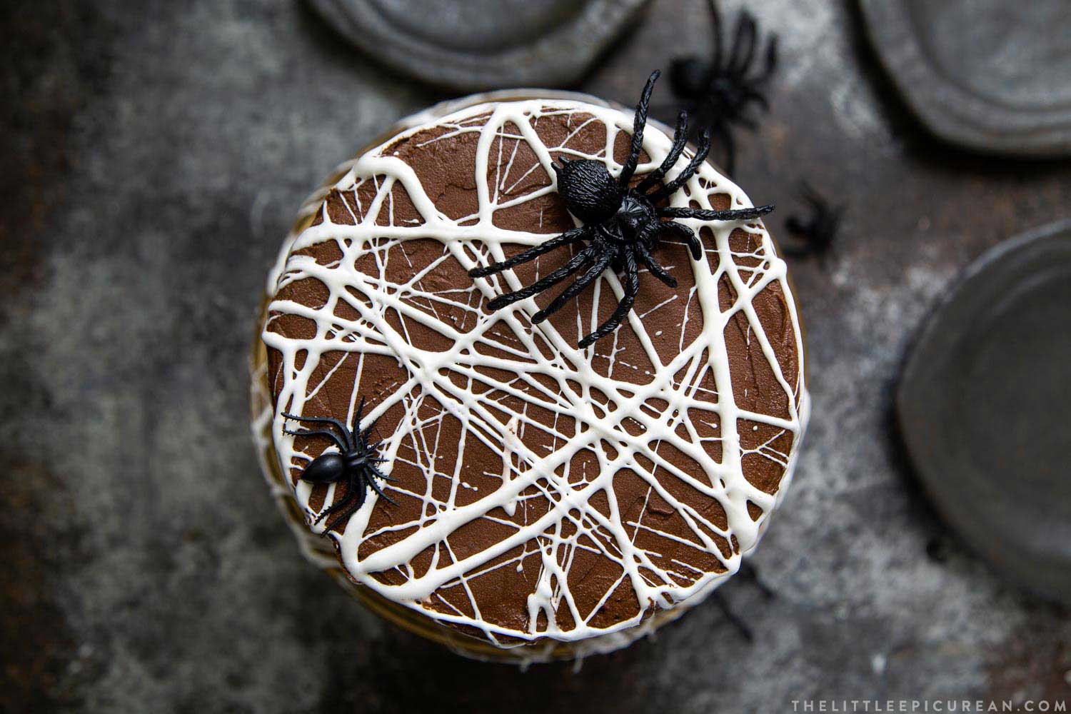 Chocolate Spider Web Cake. Three layer chocolate cake frosted with simple chocolate buttercream and decorated with marshmallow spider webs. It's the perfect Halloween treat!