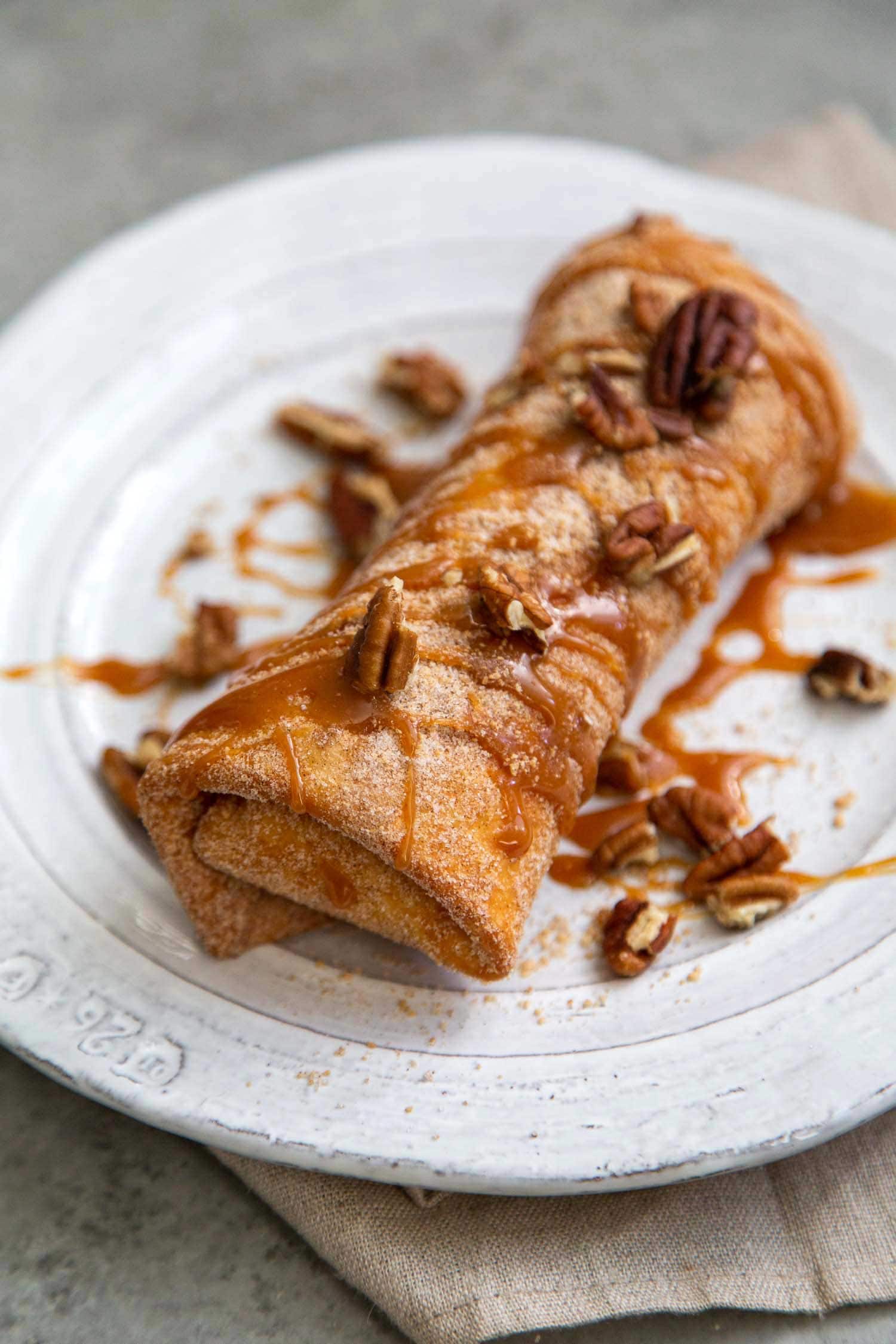 Pineapple Cheesecake Chimichangas. Crispy fried burritos filled with vanilla cream cheese and cinnamon spiced pineapple chunks. The dessert chimichangas are tossed in a sweet graham cracker powder.