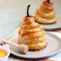 Poached Pear Puff Pastry. Pears poached in sweet vanilla cinnamon liquid. Encased in puff pastry and baked until golden. #pear #peardessert #falldessert #puffpastry