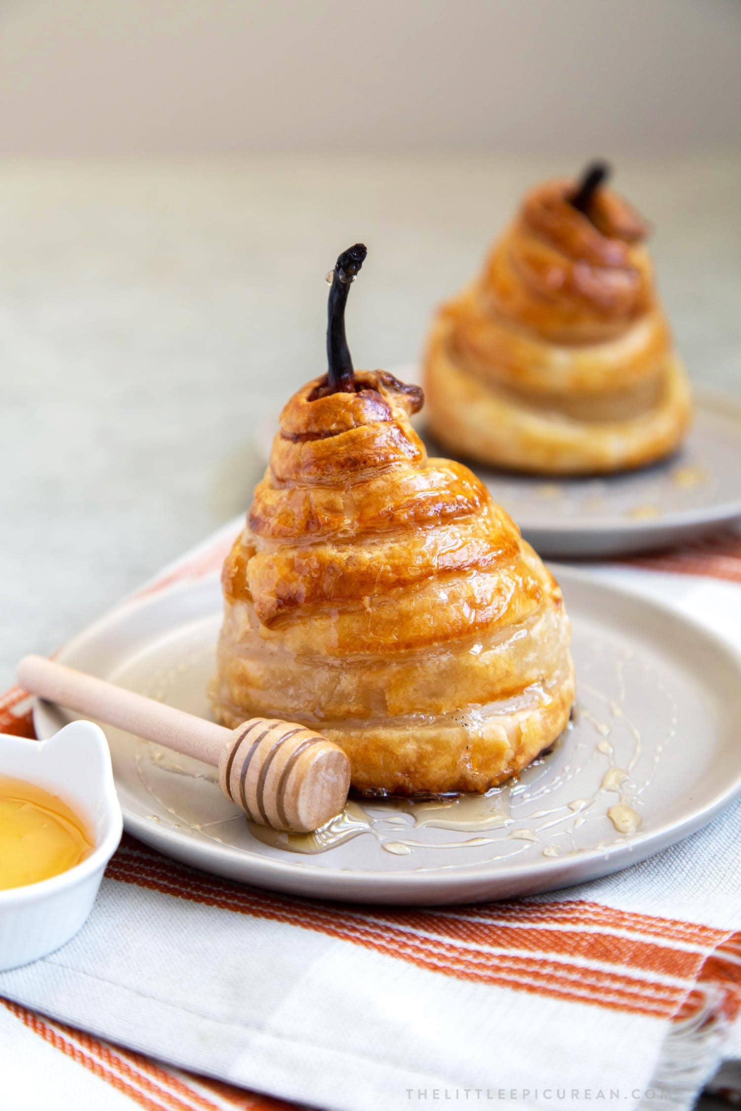 Poached Pear Puff Pastry. Pears poached in sweet vanilla cinnamon liquid. Encased in puff pastry and baked until golden. #pear #peardessert #falldessert #puffpastry