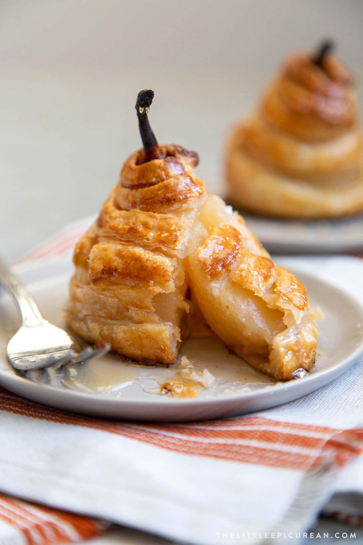 Poached Pear Puff Pastry. Pears poached in sweet vanilla cinnamon liquid. Encased in puff pastry and baked until golden. #pear #peardessert #falldessert #puffpastry