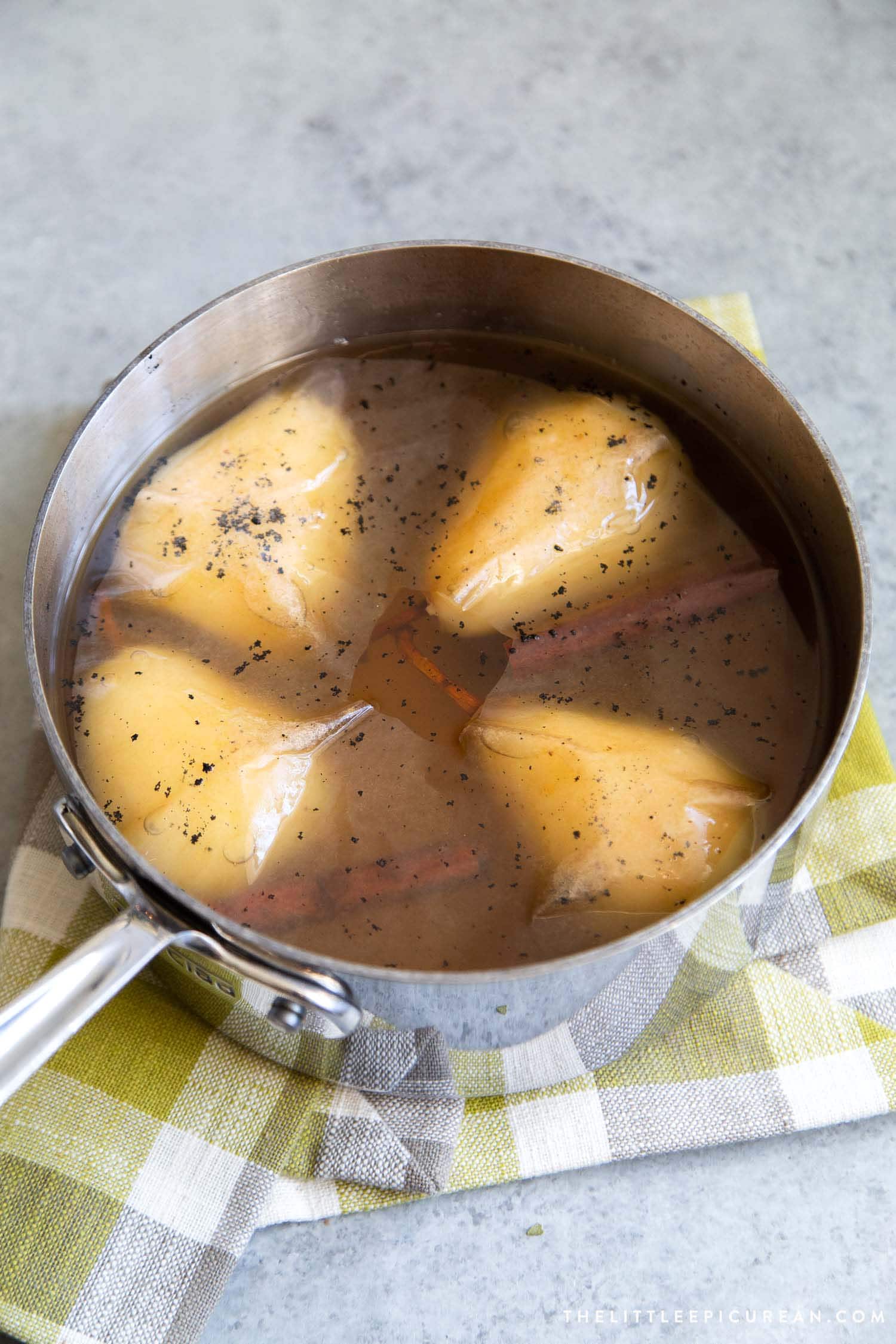 Pears are poached in a sweet vanilla cinnamon liquid until fragrant and flavorful. They are chilled overnight before serving. 