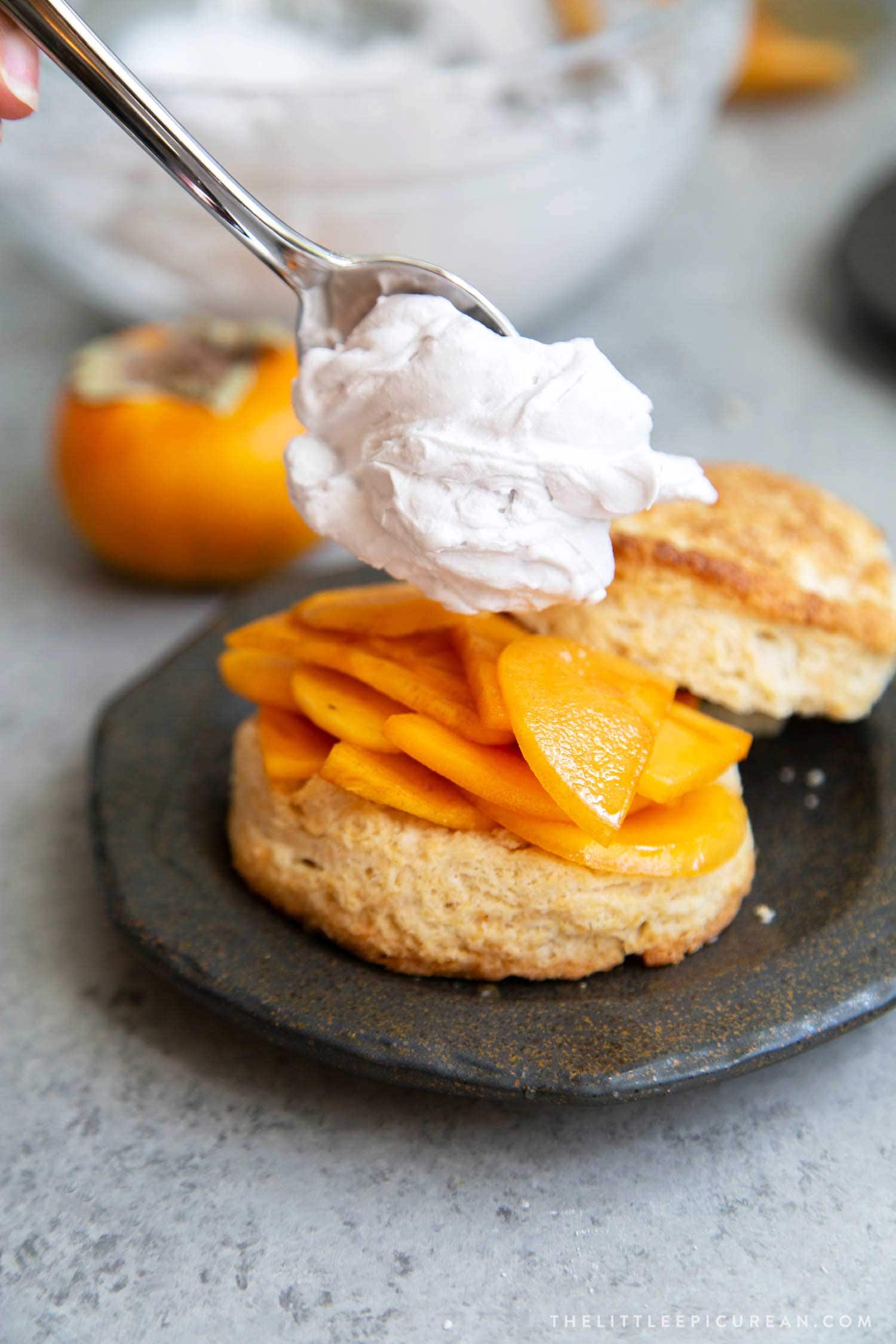 Coconut Persimmon Shortcake. A new spin strawberry shortcake. This dessert features coconut milk shortcake biscuits filled with sliced persimmons and coconut whipped cream. #persimmons #fuyupersimmons #fallbaking #shortcake #biscuits