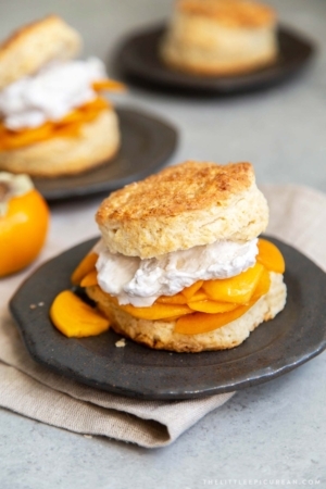 Coconut Persimmon Shortcake. A new spin strawberry shortcake. This dessert features coconut milk shortcake biscuits filled with sliced persimmons and coconut whipped cream. #shortcake #persimmons #fallbaking #falldesserts