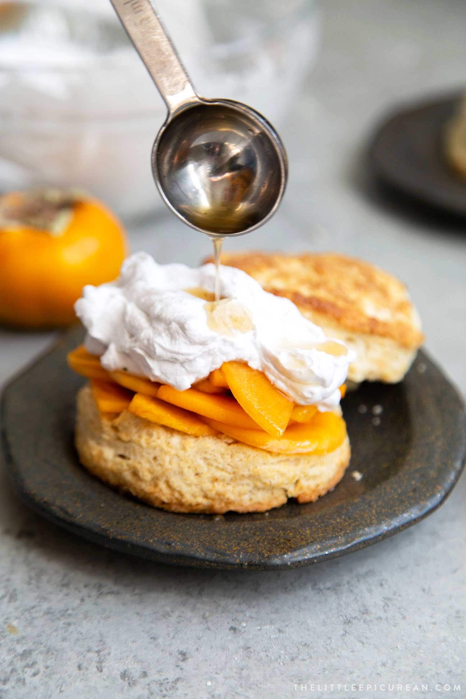 Coconut Persimmon Shortcake. A new spin strawberry shortcake. This dessert features coconut milk shortcake biscuits filled with sliced persimmons and coconut whipped cream. #persimmons #fuyupersimmons #fallbaking #shortcake #biscuits