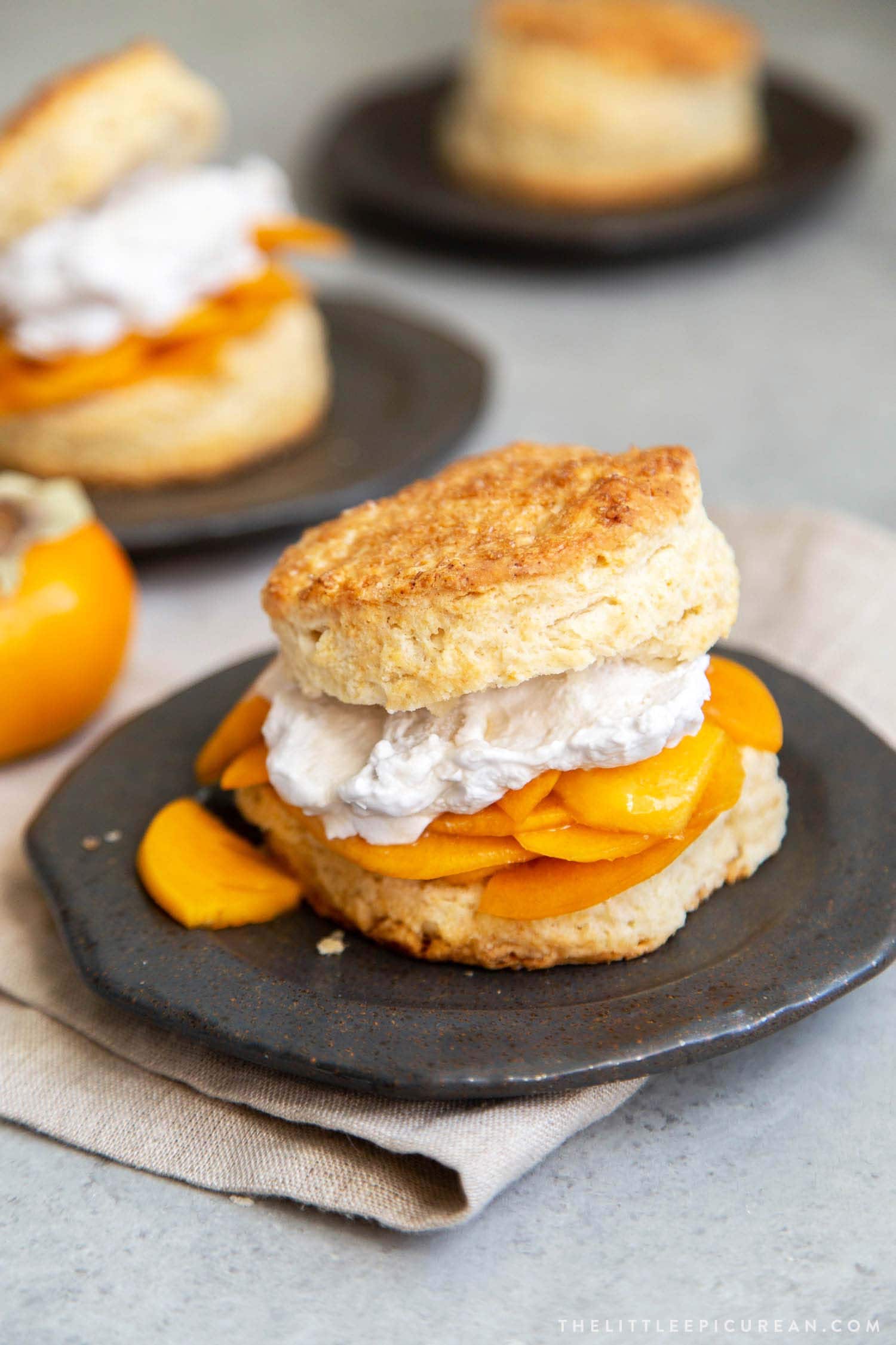 Coconut Persimmon Shortcake. A new spin strawberry shortcake. This dessert features coconut milk shortcake biscuits filled with sliced persimmons and coconut whipped cream. #shortcake #persimmons #fallbaking #falldesserts