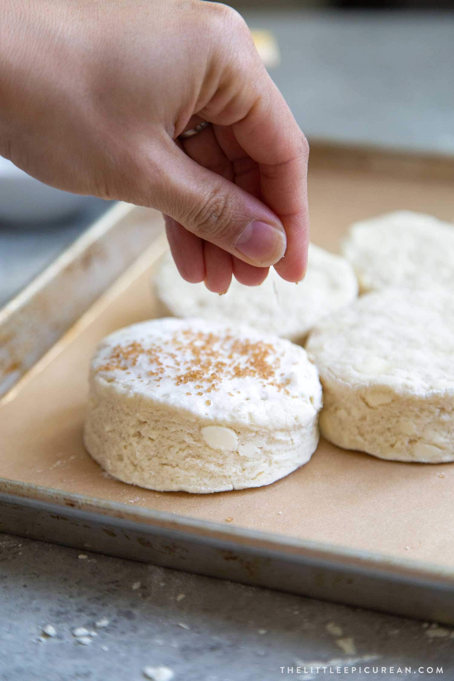 Coconut shortcake biscuits are brushed with cream and topped with turbinado sugar before baking. 